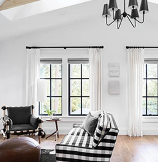 Living room facing C650 Ultra Series black casement windows with colonial grid pattern