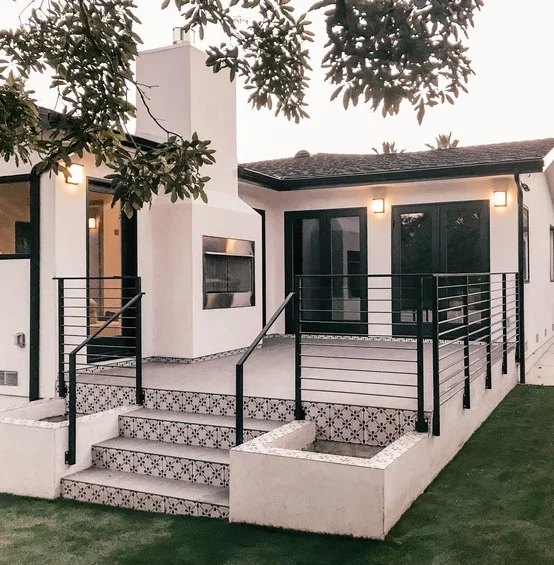 Exterior of home showing detailed door and black windows 
