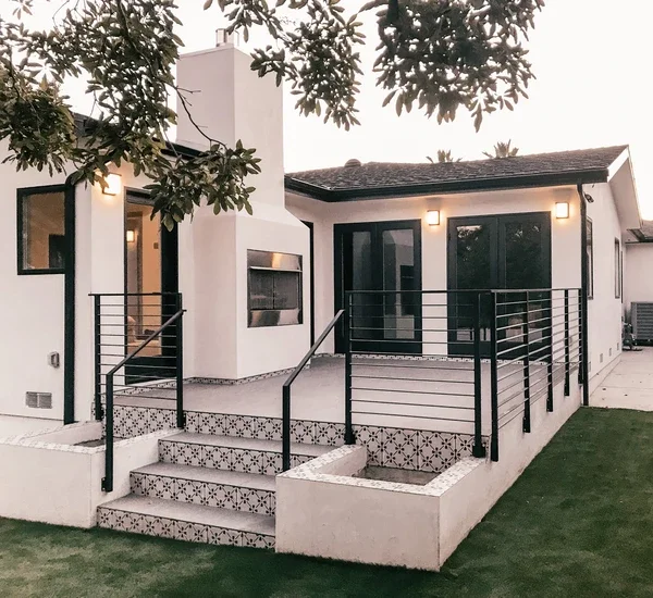 Exterior of home showing detailed door and black windows 