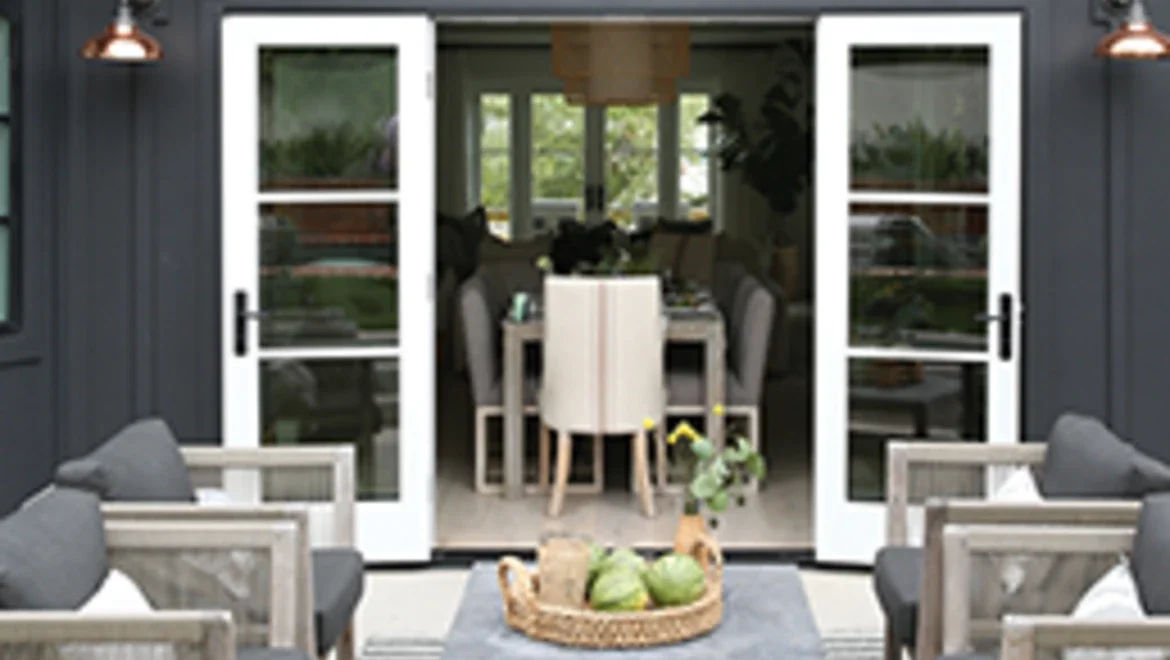 Exterior of home facing outswing patio doors leading into inside of home