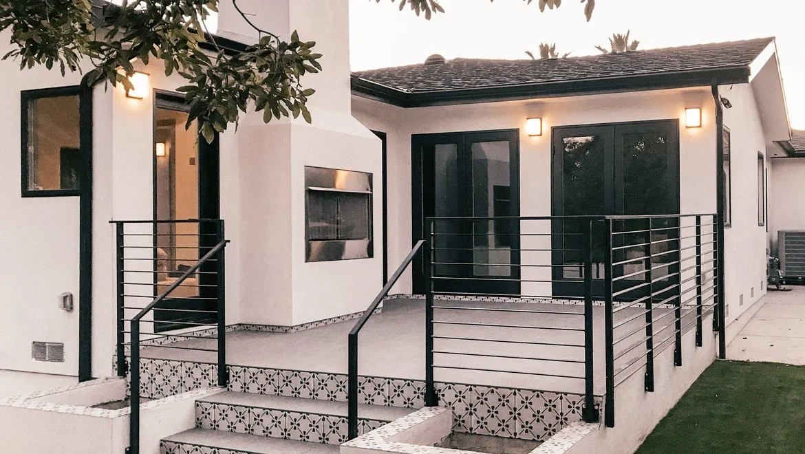 Exterior of home showing detailed door and black windows 