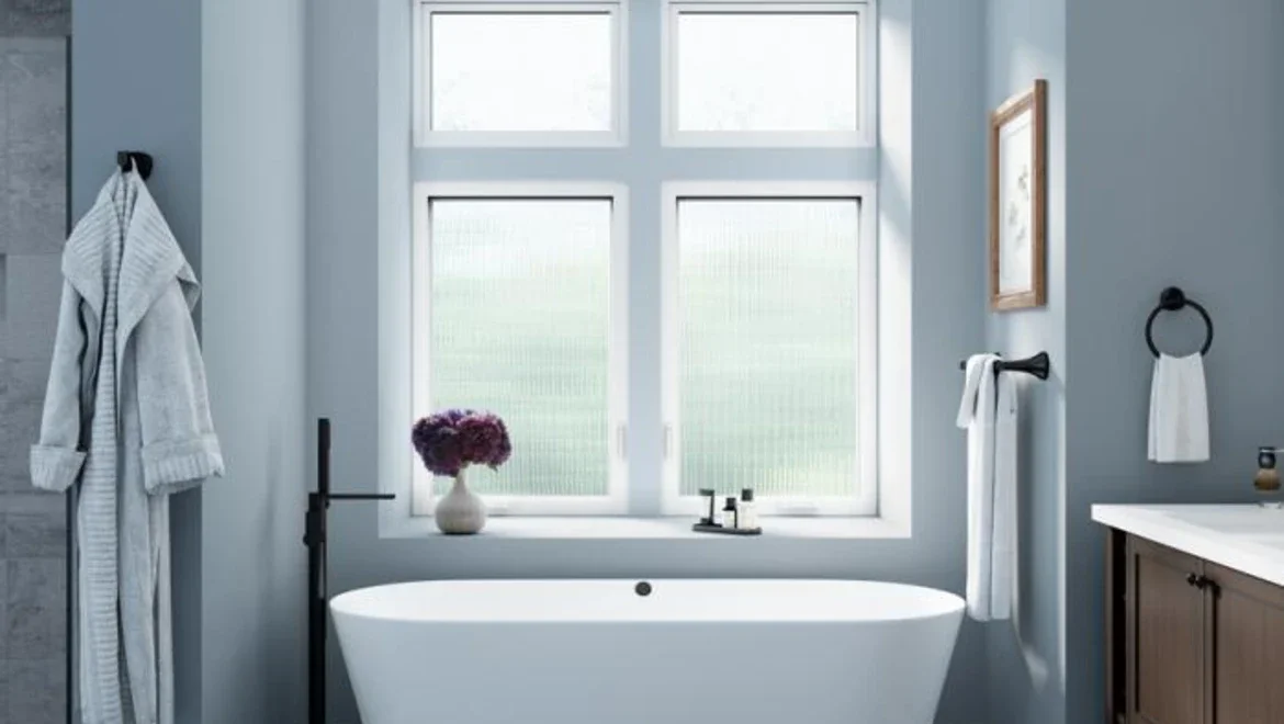Bathroom facing large tub with white casement windows with privacy glass 