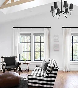 Living room facing C650 Ultra Series black casement windows with colonial grid pattern