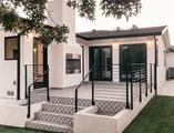 Exterior of home showing detailed door and black windows 