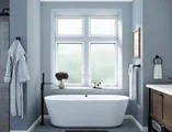 Bathroom facing large tub with white casement windows with privacy glass 