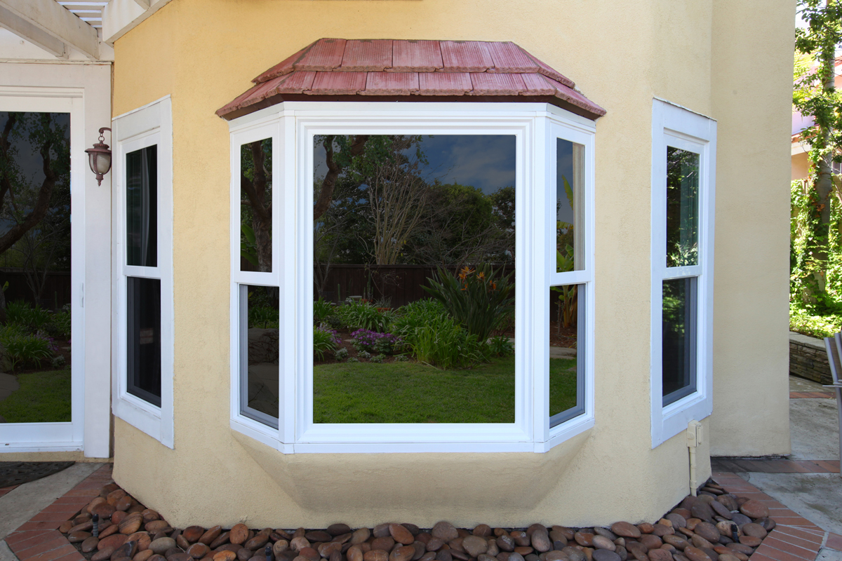 Yellow house with Tuscany® Series | V400 white bay window