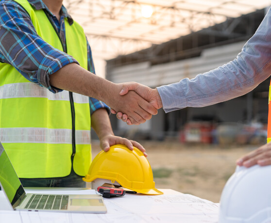 Two men in construction shaking hands.