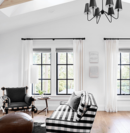 Living room facing C650 Ultra Series black casement windows with colonial grid pattern