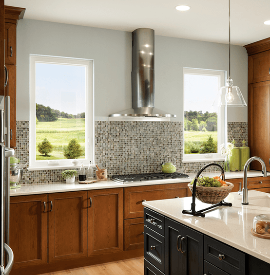 dark stained cabinets facing stove top with two casement windows on either side