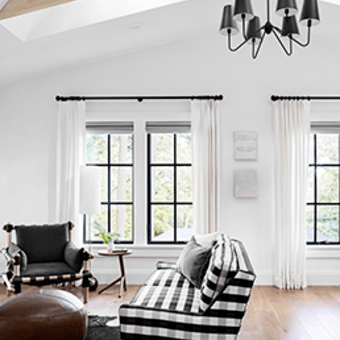 Living room facing C650 Ultra Series black casement windows with colonial grid pattern