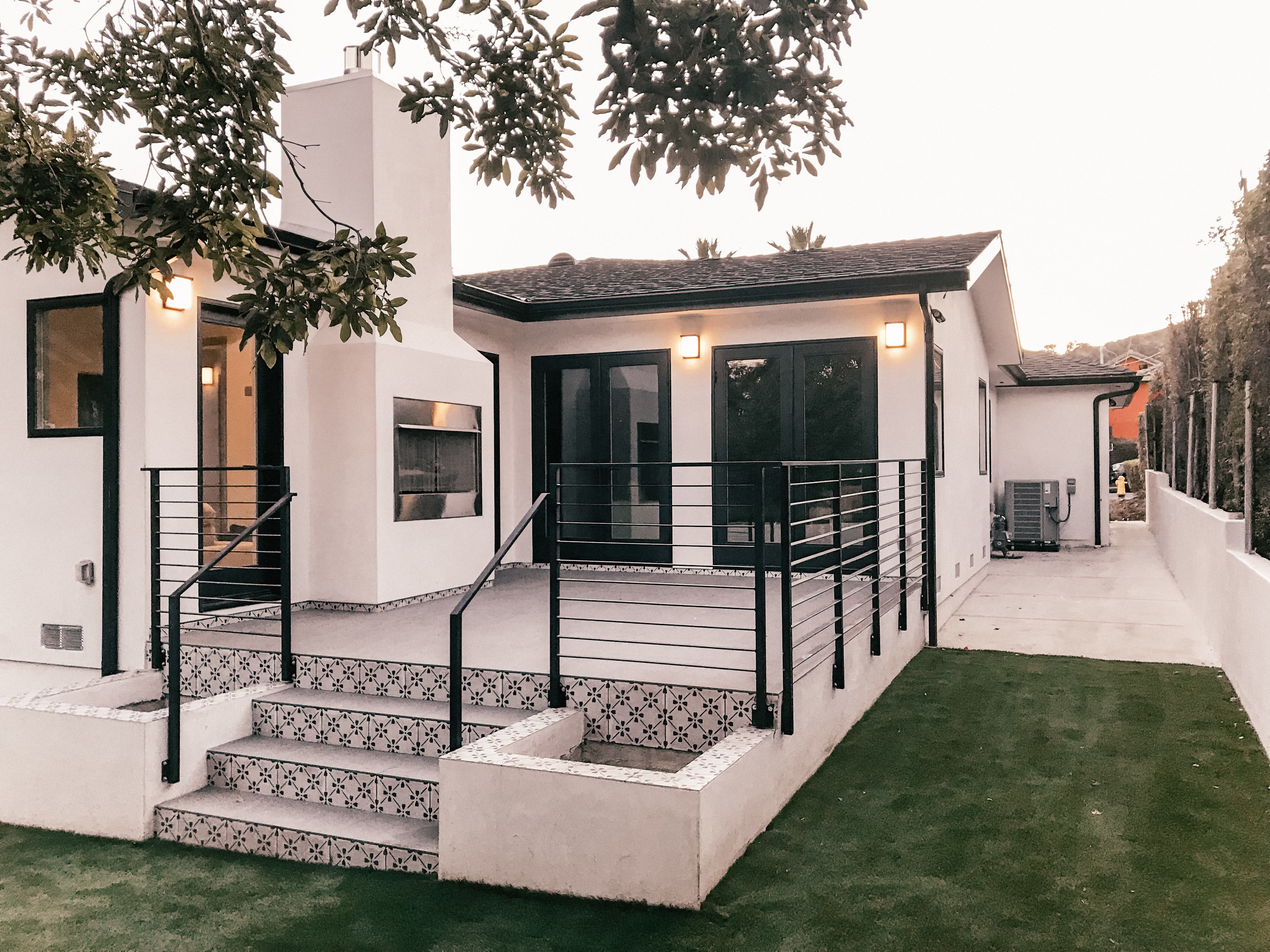 Exterior of home showing detailed door and black windows 